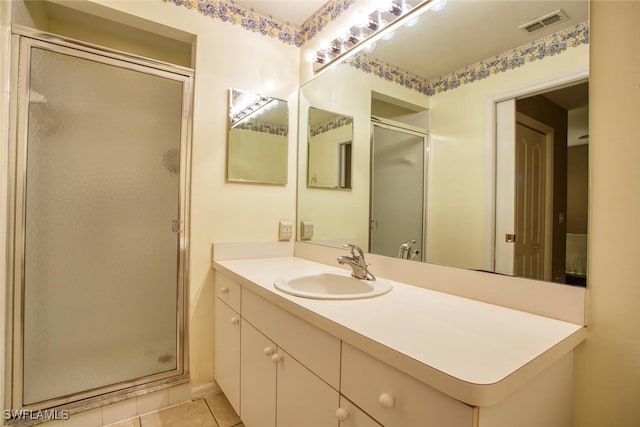 bathroom with tile patterned flooring, vanity, and a shower with door