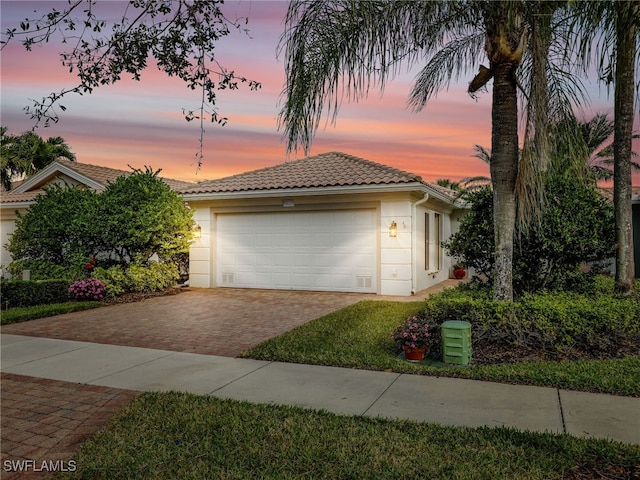 view of front of house featuring a tiled roof, decorative driveway, and stucco siding