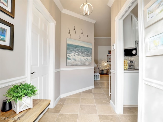 corridor featuring ornamental molding, light tile patterned flooring, and baseboards