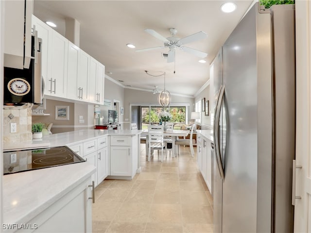 kitchen with ornamental molding, freestanding refrigerator, a peninsula, light countertops, and white cabinetry