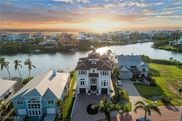 aerial view at dusk featuring a water view