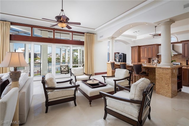 living room with ceiling fan, ornamental molding, and ornate columns