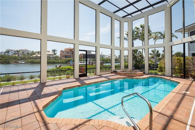 view of pool featuring an in ground hot tub, a patio area, and a water view