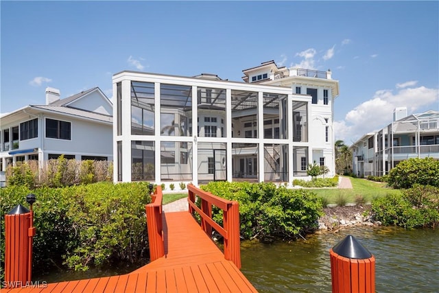 back of property with a water view and a lanai