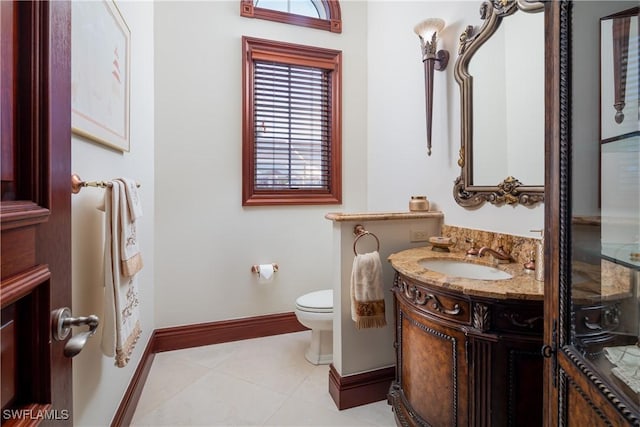 bathroom with toilet, vanity, and tile patterned flooring