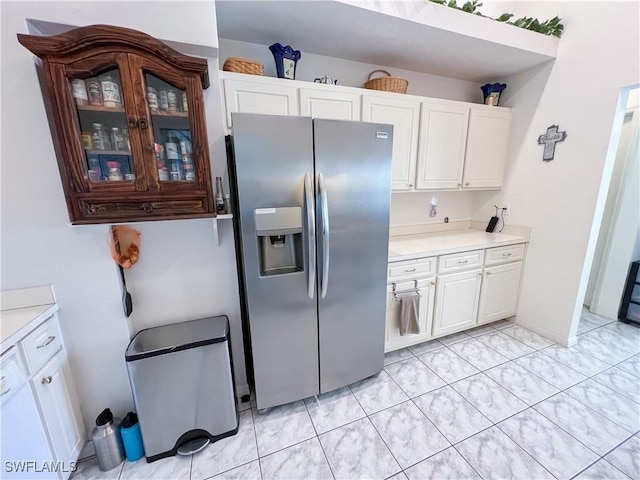 kitchen featuring white cabinets and stainless steel fridge