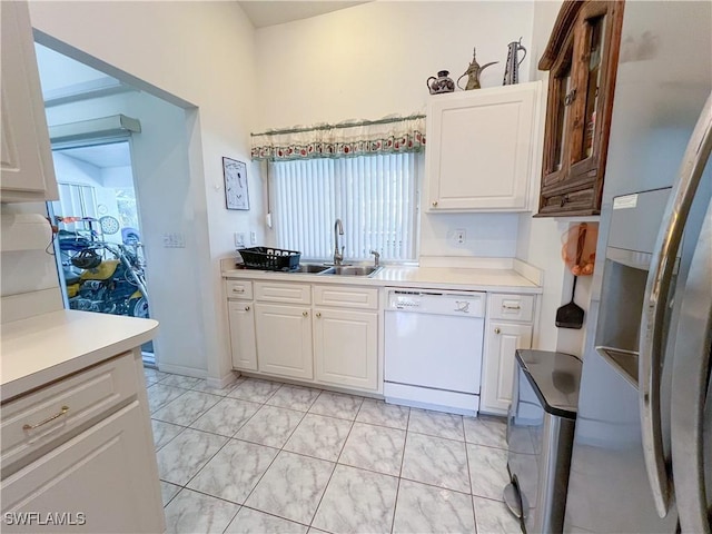 kitchen featuring stainless steel fridge, white cabinetry, dishwasher, and sink