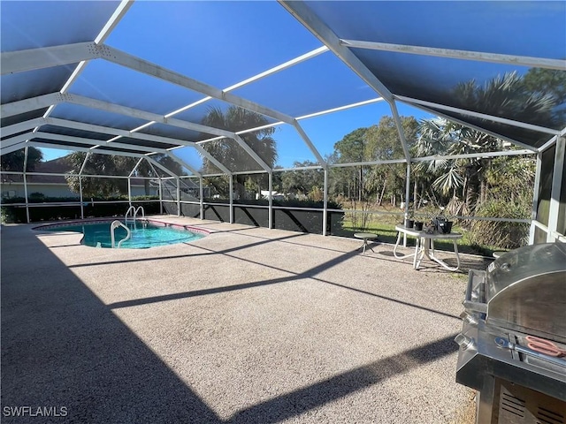 view of pool featuring a patio area, area for grilling, and glass enclosure