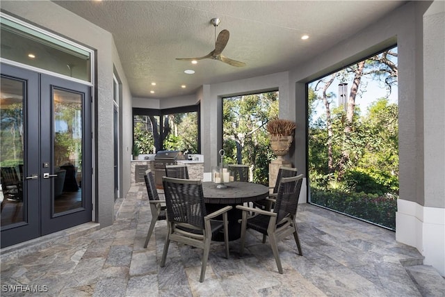 sunroom / solarium featuring a ceiling fan and french doors