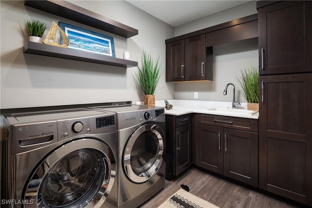 clothes washing area with dark wood-type flooring, cabinet space, independent washer and dryer, and a sink