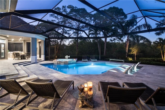 view of pool featuring a patio area, glass enclosure, and a pool with connected hot tub