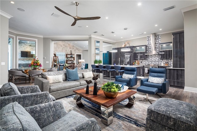 living room featuring visible vents, ornamental molding, a ceiling fan, wood finished floors, and recessed lighting