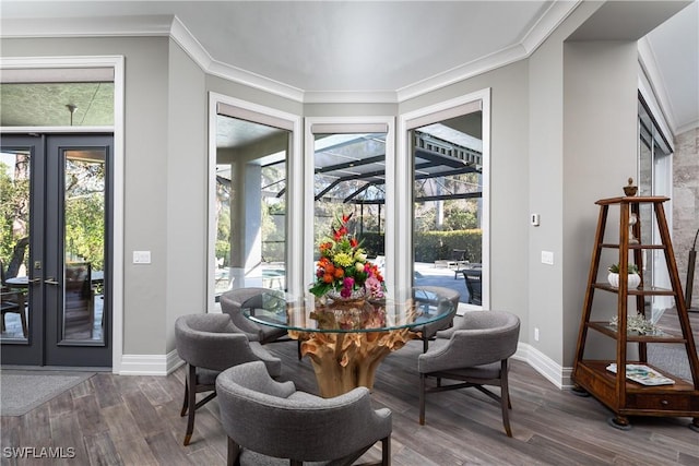 dining area featuring baseboards, wood finished floors, and crown molding