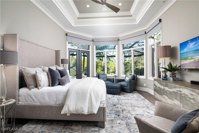 bedroom featuring wood finished floors, baseboards, a tray ceiling, ornamental molding, and french doors