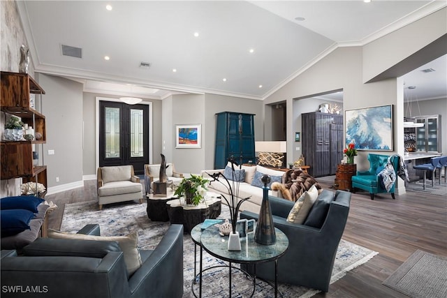 living area with visible vents, wood finished floors, lofted ceiling, and ornamental molding