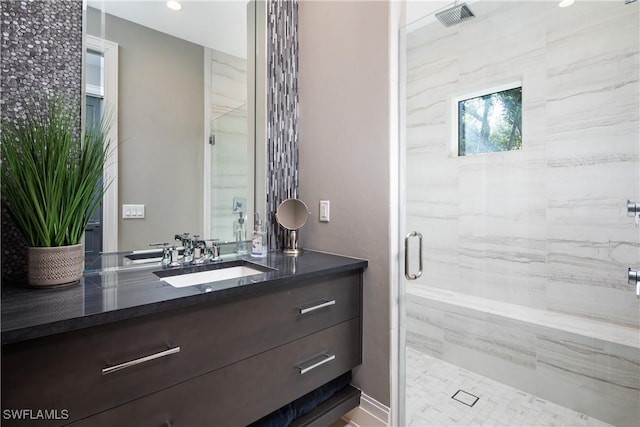 bathroom featuring visible vents, a stall shower, and vanity