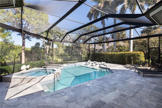 view of pool with a lanai, a pool with connected hot tub, and a patio