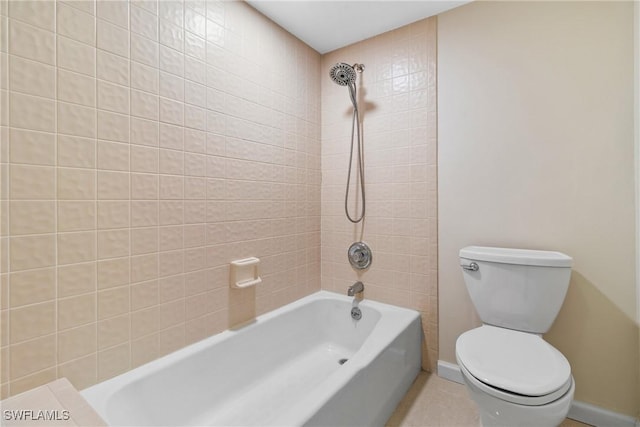 bathroom featuring tiled shower / bath combo and toilet