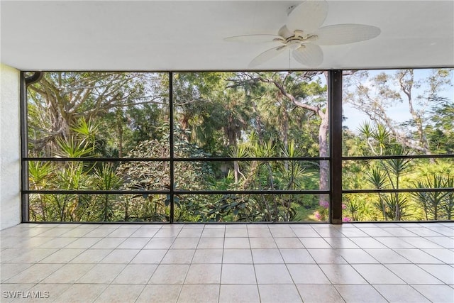 unfurnished sunroom with ceiling fan