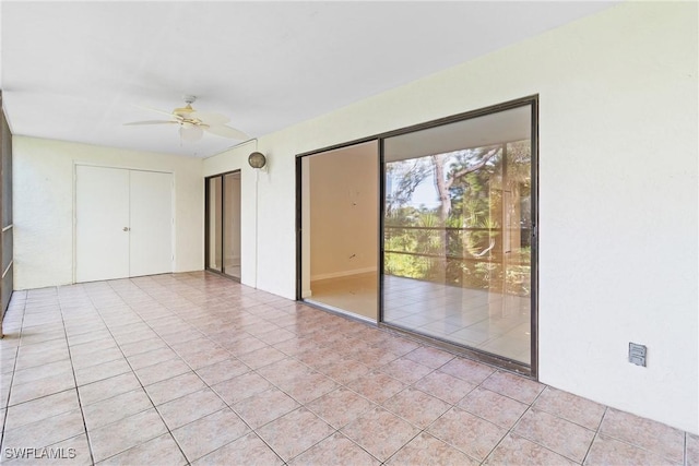 tiled empty room featuring ceiling fan