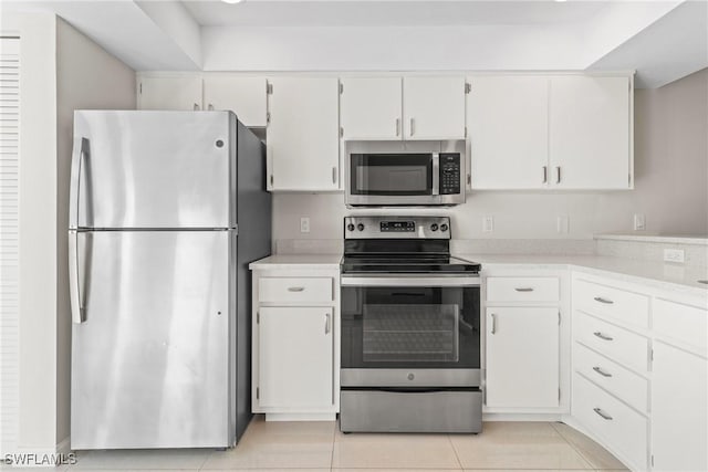 kitchen featuring light tile patterned flooring, white cabinets, and stainless steel appliances