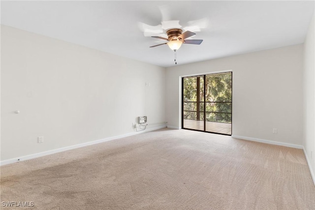 carpeted spare room featuring ceiling fan