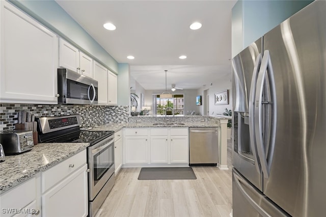 kitchen featuring white cabinets, sink, kitchen peninsula, and stainless steel appliances