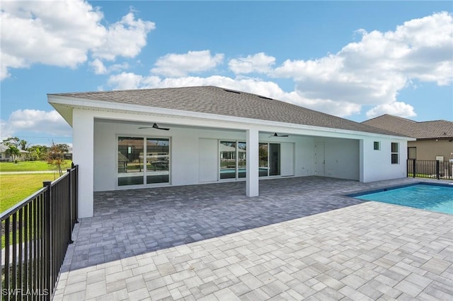 rear view of house featuring ceiling fan, a patio area, and a fenced in pool