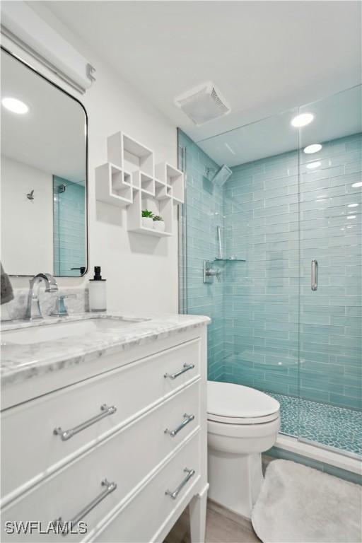 bathroom with vanity, toilet, and an enclosed shower