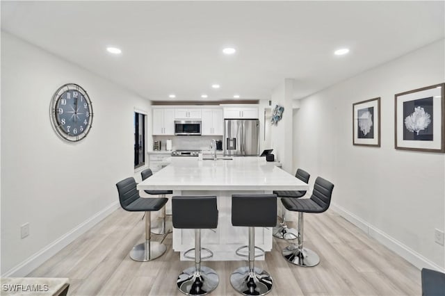 dining area with sink and light hardwood / wood-style flooring