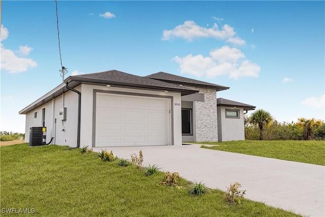 view of front facade featuring central AC unit, a garage, and a front yard