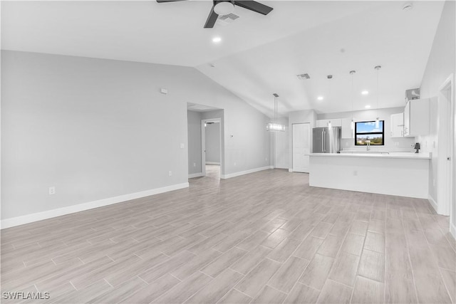 unfurnished living room featuring ceiling fan and vaulted ceiling