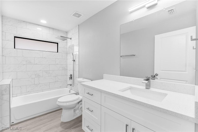 full bathroom with toilet, vanity, and tiled shower / bath