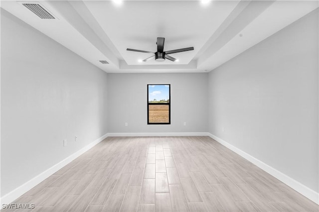 unfurnished room featuring a tray ceiling and ceiling fan