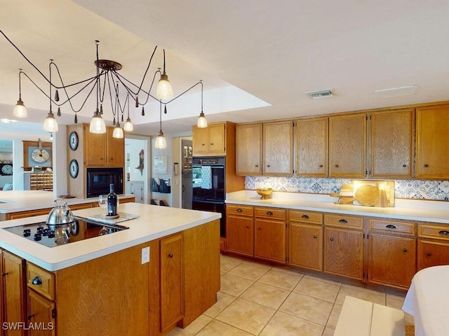 kitchen with light tile patterned flooring, decorative light fixtures, tasteful backsplash, a kitchen island with sink, and black appliances