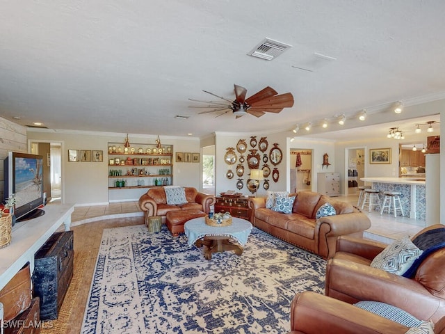 living room with ceiling fan and ornamental molding