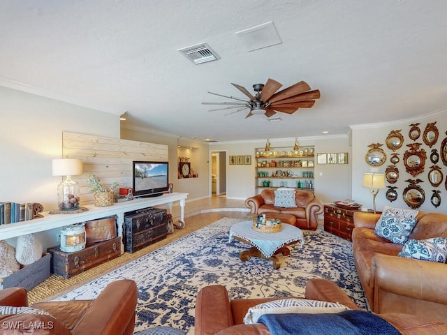 living room with ornamental molding and ceiling fan