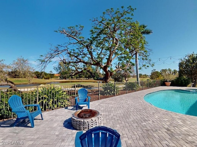 view of swimming pool featuring a patio area and a fire pit