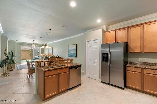 kitchen with appliances with stainless steel finishes, crown molding, sink, dark stone countertops, and hanging light fixtures