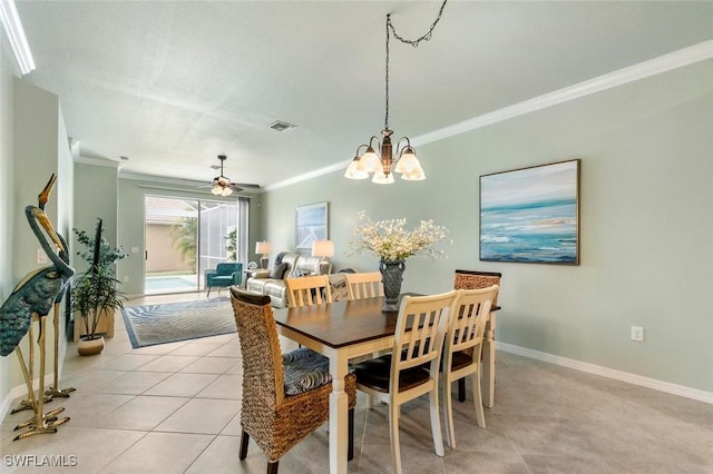 dining area with light tile patterned flooring, ceiling fan with notable chandelier, and ornamental molding