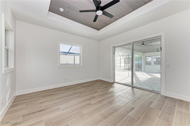 spare room with ceiling fan, a raised ceiling, and wood ceiling