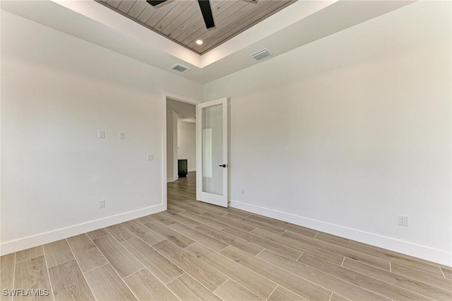 unfurnished room featuring french doors, light wood-type flooring, wood ceiling, a raised ceiling, and ceiling fan