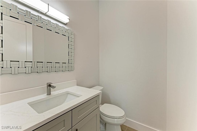 bathroom with tile patterned flooring, vanity, and toilet