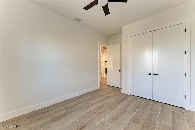 unfurnished bedroom featuring ceiling fan and a closet