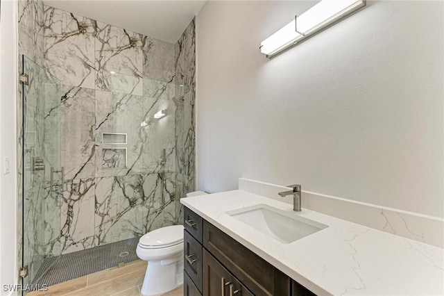 bathroom featuring toilet, an enclosed shower, and vanity