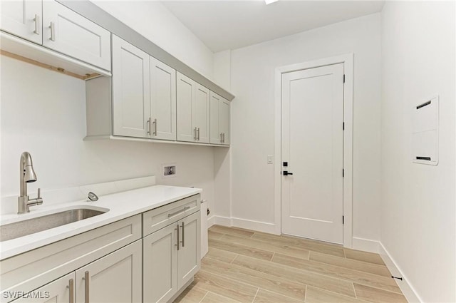 clothes washing area with cabinets, sink, and hookup for a washing machine