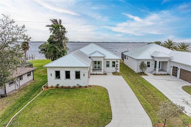 modern farmhouse style home featuring a front lawn, a water view, and a garage