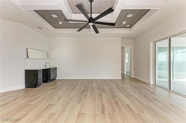 unfurnished living room with a raised ceiling, ceiling fan, light hardwood / wood-style flooring, and wood ceiling