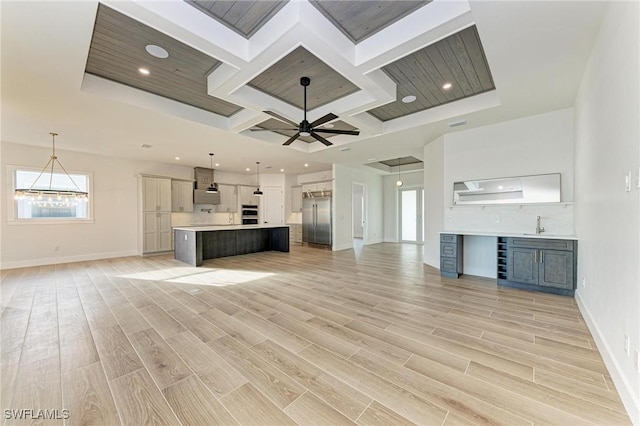 unfurnished living room with ceiling fan, light hardwood / wood-style floors, and coffered ceiling