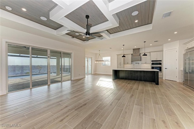 unfurnished living room with ceiling fan, a water view, wooden ceiling, and light wood-type flooring